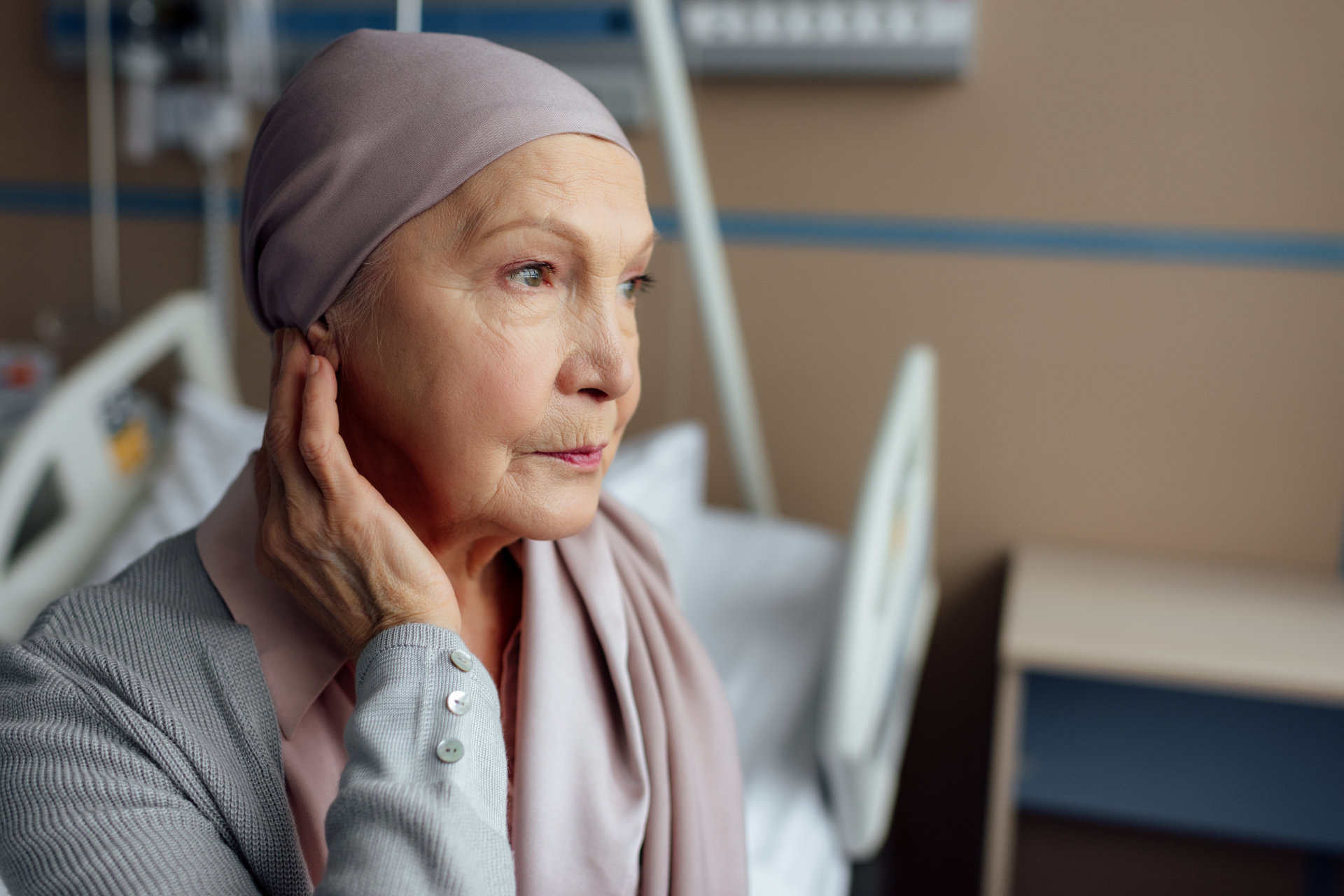 ältere Frau mit Krebs, die im Krankenhaus auf dem Bett sitzt